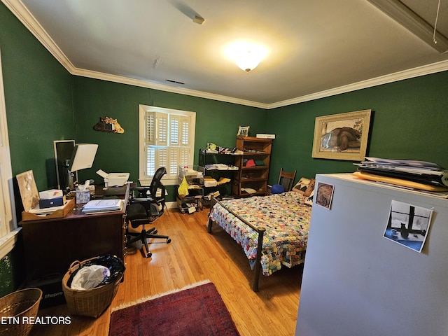 bedroom featuring wood finished floors and crown molding