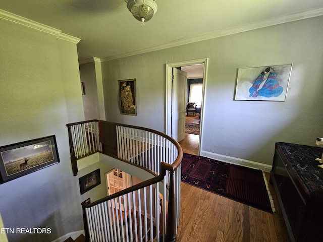 stairway featuring crown molding, baseboards, and wood finished floors