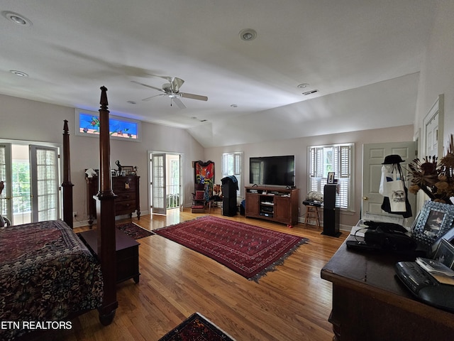 bedroom with lofted ceiling, multiple windows, and wood finished floors