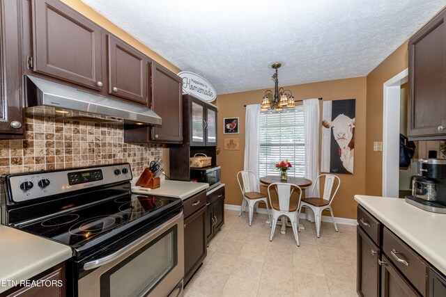 kitchen featuring decorative backsplash, light tile patterned flooring, an inviting chandelier, decorative light fixtures, and stainless steel appliances