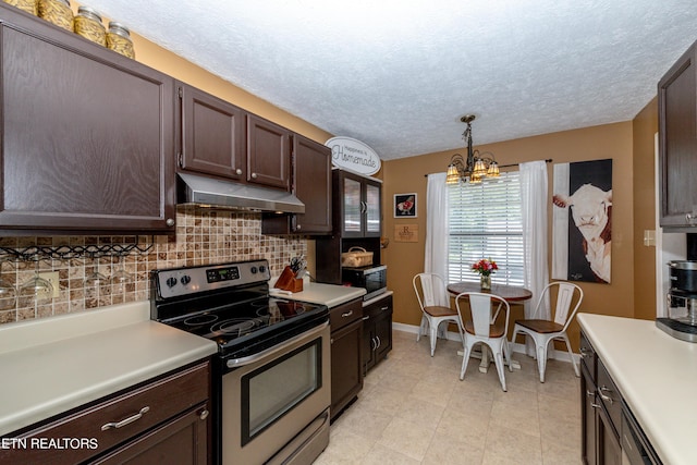 kitchen featuring pendant lighting, a notable chandelier, appliances with stainless steel finishes, backsplash, and light tile patterned floors