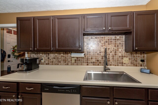 kitchen with a textured ceiling, stainless steel dishwasher, tasteful backsplash, and sink