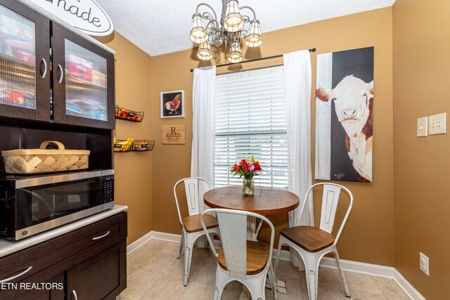 tiled dining room with a notable chandelier