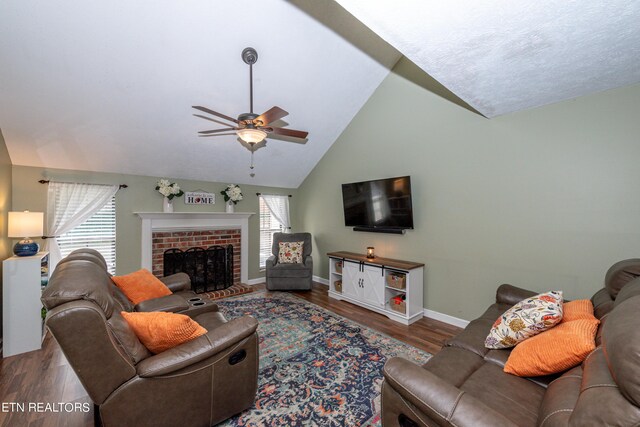 living room with a brick fireplace, ceiling fan, hardwood / wood-style floors, and vaulted ceiling