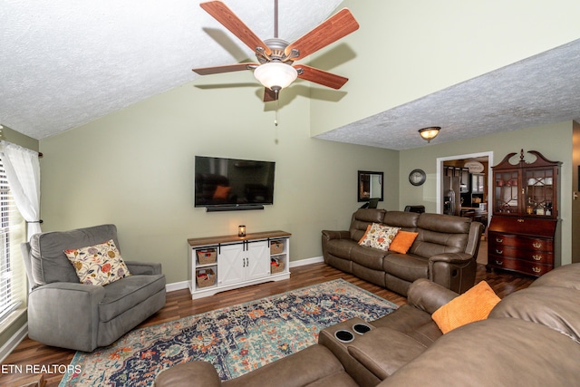 living room with ceiling fan, dark wood-type flooring, a textured ceiling, and lofted ceiling