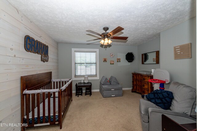 bedroom featuring ceiling fan, a textured ceiling, and light colored carpet