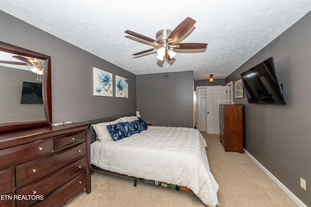 bedroom with light carpet, a textured ceiling, and ceiling fan