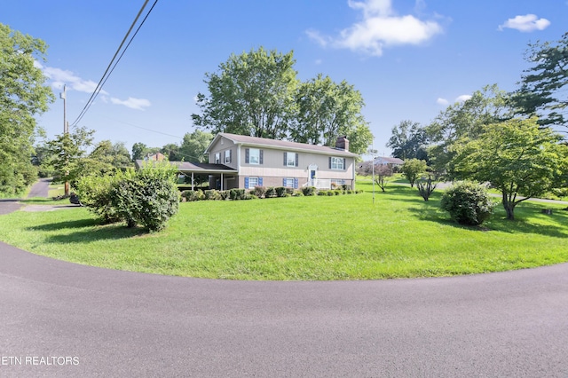 view of front of house featuring a front lawn and a chimney