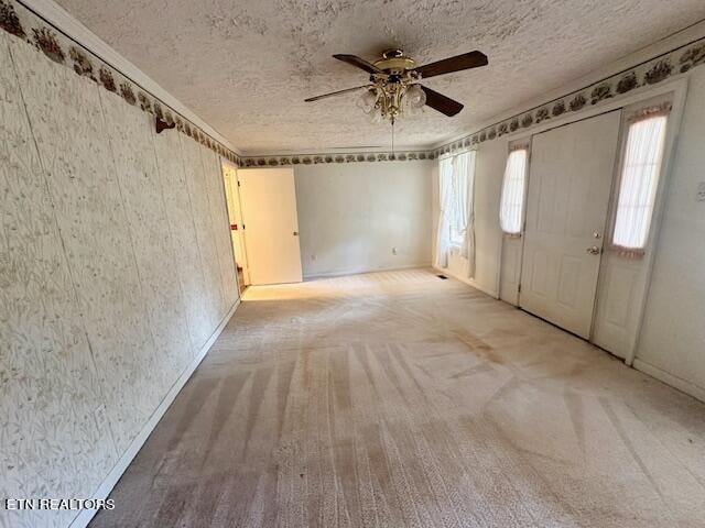 carpeted entryway featuring ceiling fan and a textured ceiling