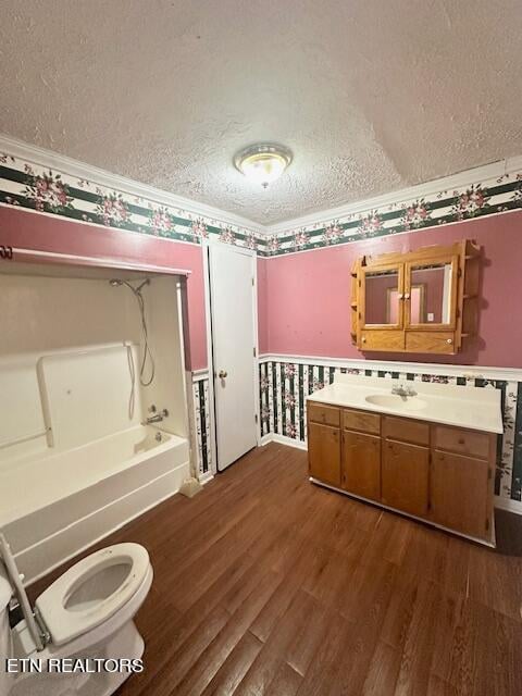 interior space featuring a textured ceiling, toilet, vanity, and wood-type flooring