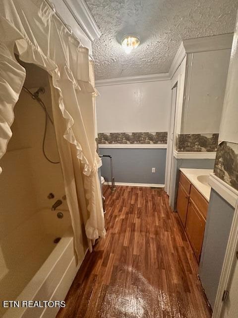 bathroom featuring a textured ceiling, shower / bath combo with shower curtain, vanity, and hardwood / wood-style flooring