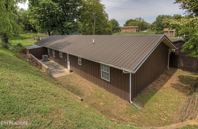 view of property exterior featuring cooling unit and a lawn