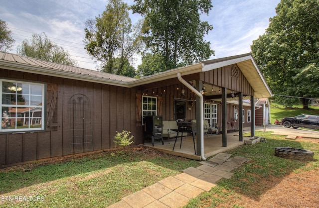 rear view of property featuring a patio and a yard