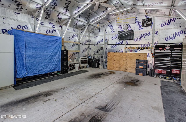 interior space featuring ceiling fan, a workshop area, and white refrigerator