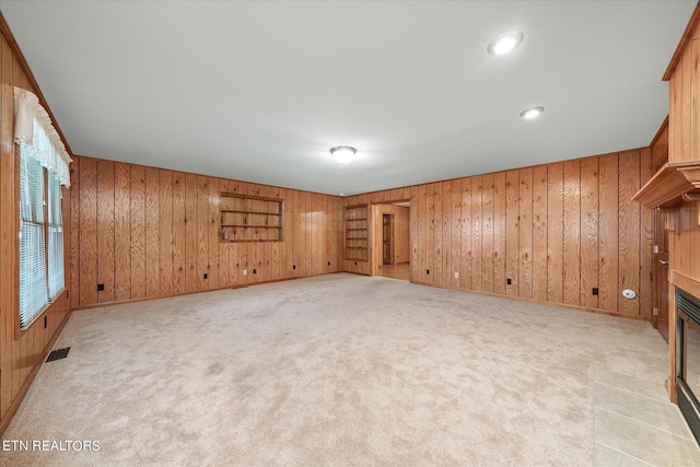 empty room with wooden walls and light colored carpet