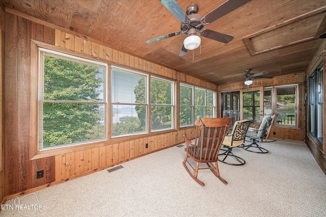 sunroom / solarium featuring plenty of natural light, wood ceiling, and ceiling fan