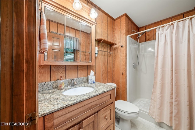 bathroom with toilet, tile patterned floors, wooden walls, a shower with shower curtain, and vanity