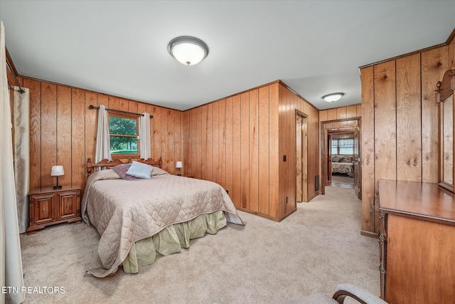 bedroom featuring wood walls and light colored carpet