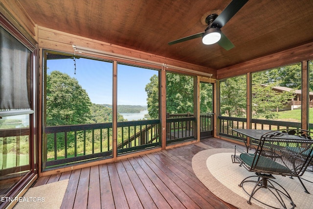 sunroom / solarium with ceiling fan, a water view, plenty of natural light, and wooden ceiling