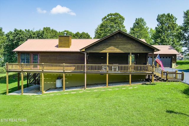 view of front of property featuring a garage, a front yard, and a deck