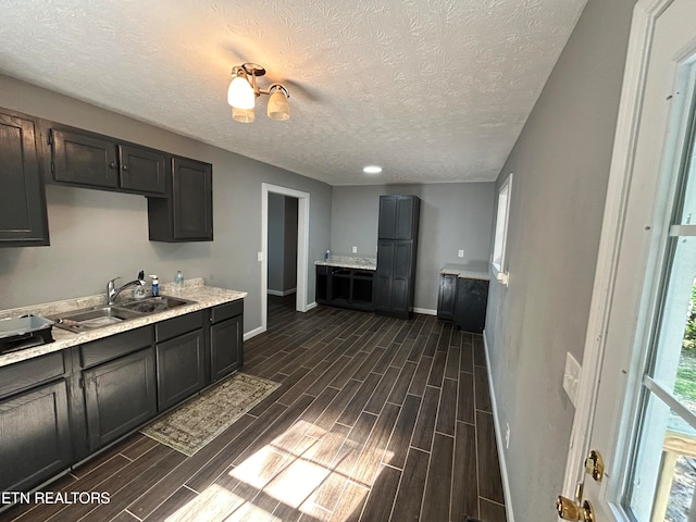 kitchen with a textured ceiling, dark hardwood / wood-style floors, and sink