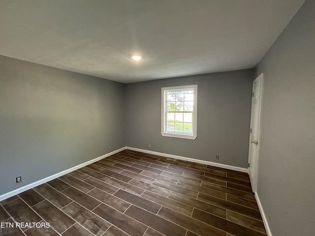 spare room with dark hardwood / wood-style flooring