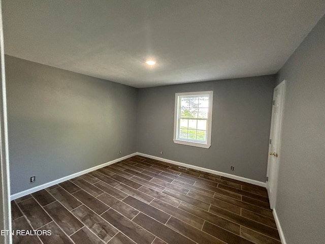 empty room with dark hardwood / wood-style flooring