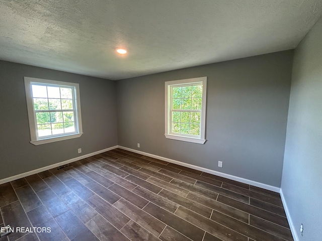 unfurnished room with a textured ceiling and hardwood / wood-style floors