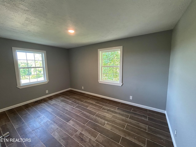 unfurnished room featuring wood-type flooring and a textured ceiling