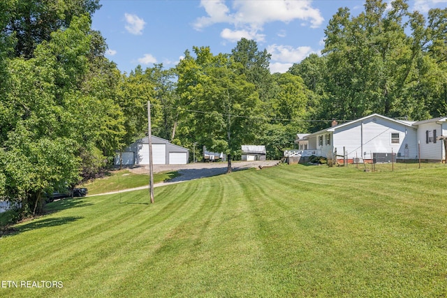 view of yard with a garage and an outbuilding