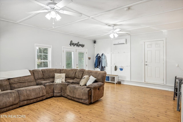 living room featuring french doors, an AC wall unit, light wood-type flooring, and ceiling fan