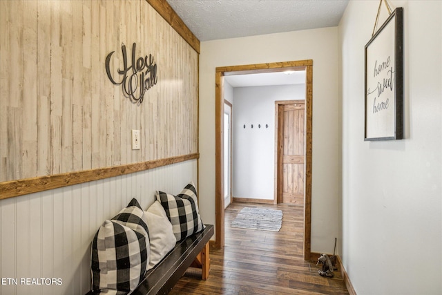 hall with dark hardwood / wood-style flooring and a textured ceiling