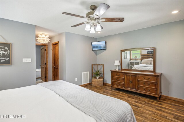 bedroom with ensuite bath, dark wood-type flooring, and ceiling fan