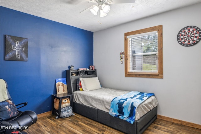 bedroom featuring ceiling fan, dark wood-type flooring, and a textured ceiling