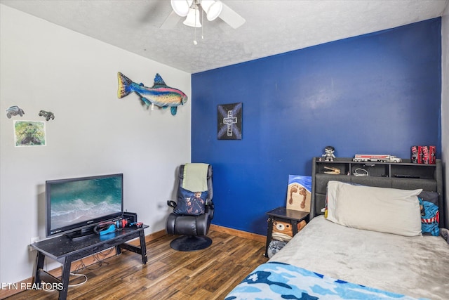 bedroom with hardwood / wood-style flooring, a textured ceiling, and ceiling fan