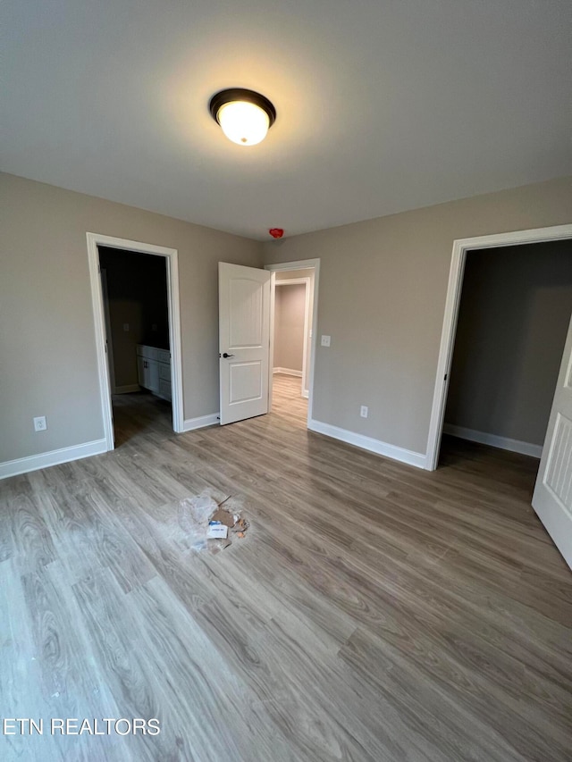 unfurnished bedroom with a closet and hardwood / wood-style flooring