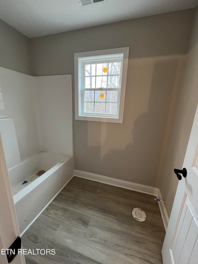 bathroom featuring hardwood / wood-style flooring and bathtub / shower combination