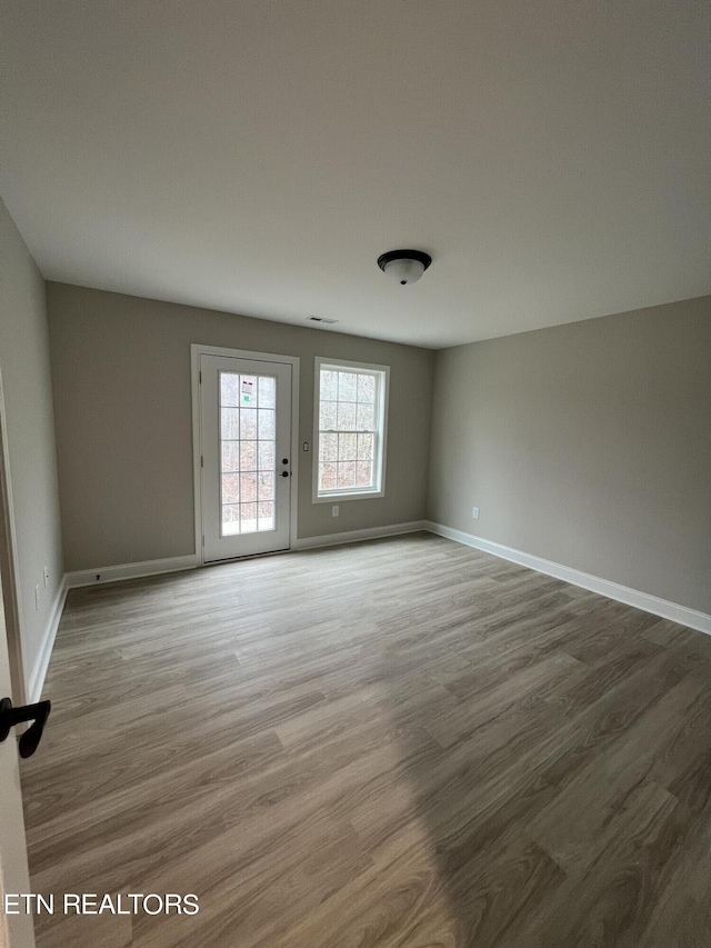 spare room with wood-type flooring