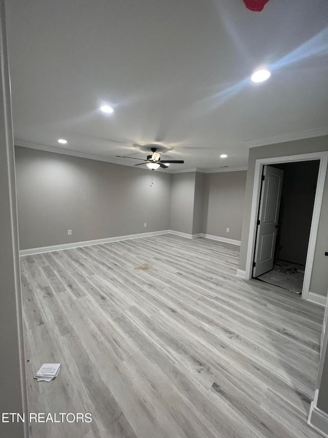 basement featuring ceiling fan, light hardwood / wood-style flooring, and ornamental molding