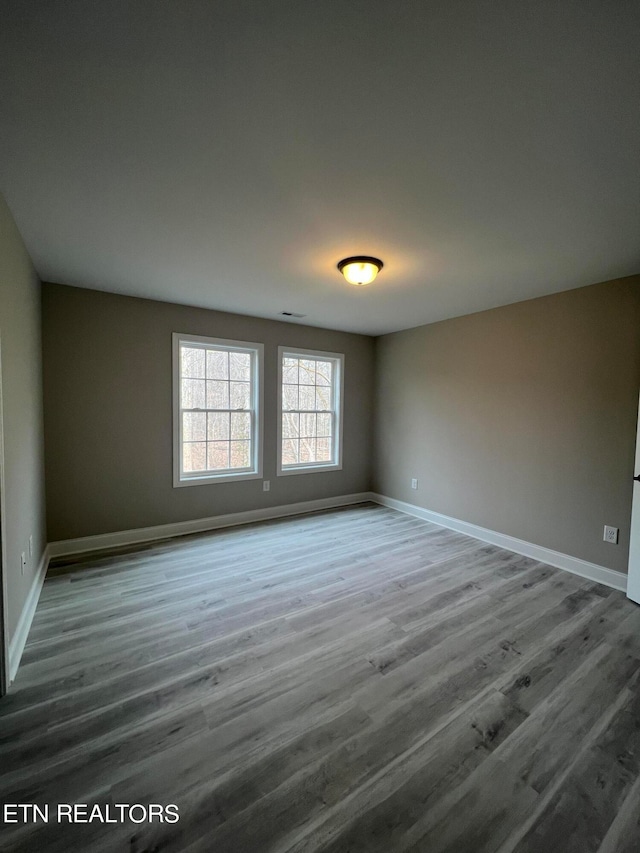 spare room with wood-type flooring