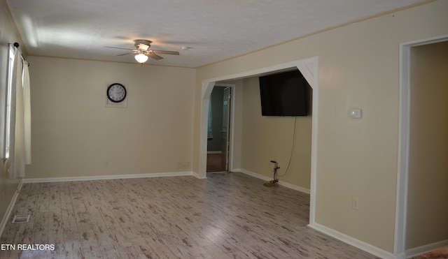 empty room with ceiling fan and light hardwood / wood-style floors