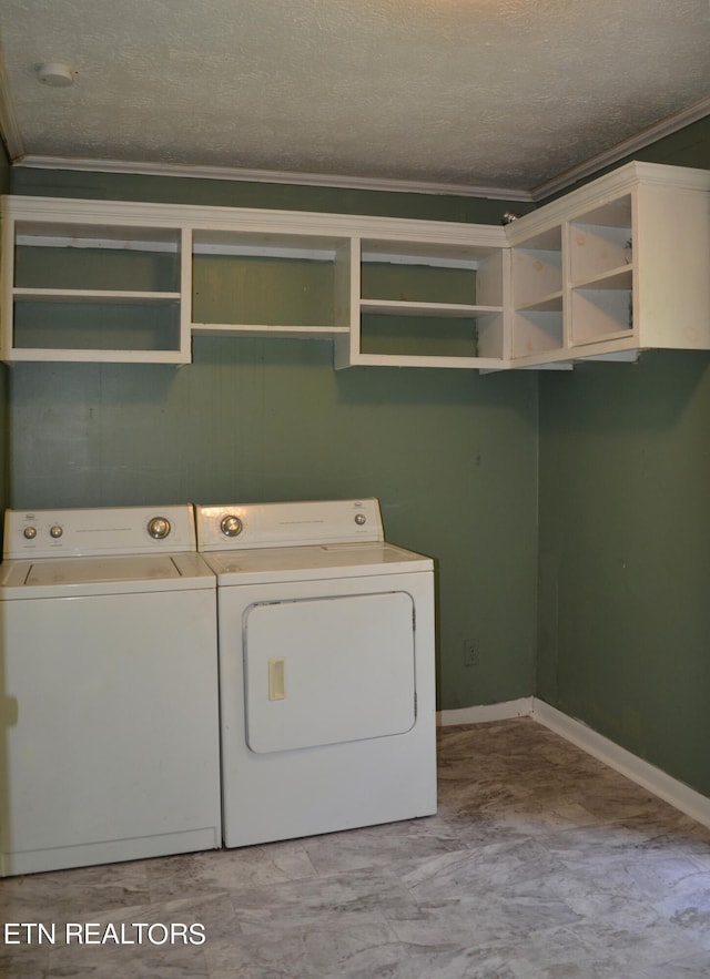 washroom with a textured ceiling, ornamental molding, and washer and dryer