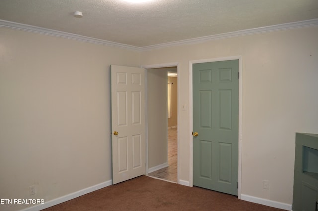 unfurnished bedroom featuring carpet flooring, ornamental molding, and a textured ceiling