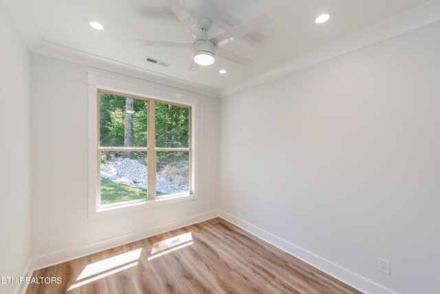 empty room with crown molding, a healthy amount of sunlight, and light hardwood / wood-style flooring