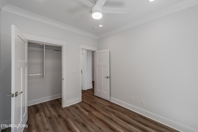 unfurnished bedroom with ornamental molding, dark hardwood / wood-style floors, ceiling fan, and a closet