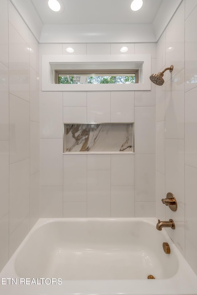 bathroom with tiled shower / bath and plenty of natural light