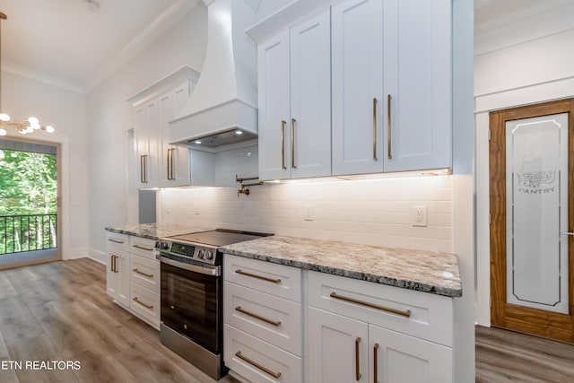 kitchen featuring white cabinets, backsplash, custom exhaust hood, electric range, and light stone countertops