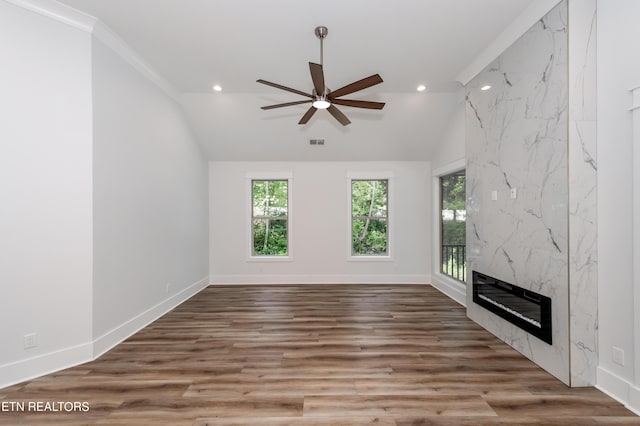 unfurnished living room featuring hardwood / wood-style flooring, a premium fireplace, vaulted ceiling, and ceiling fan