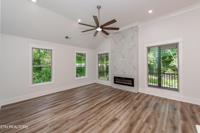 unfurnished living room featuring hardwood / wood-style flooring, lofted ceiling, a healthy amount of sunlight, and a fireplace