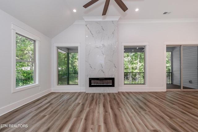 unfurnished living room featuring heating unit, hardwood / wood-style floors, lofted ceiling, and a premium fireplace